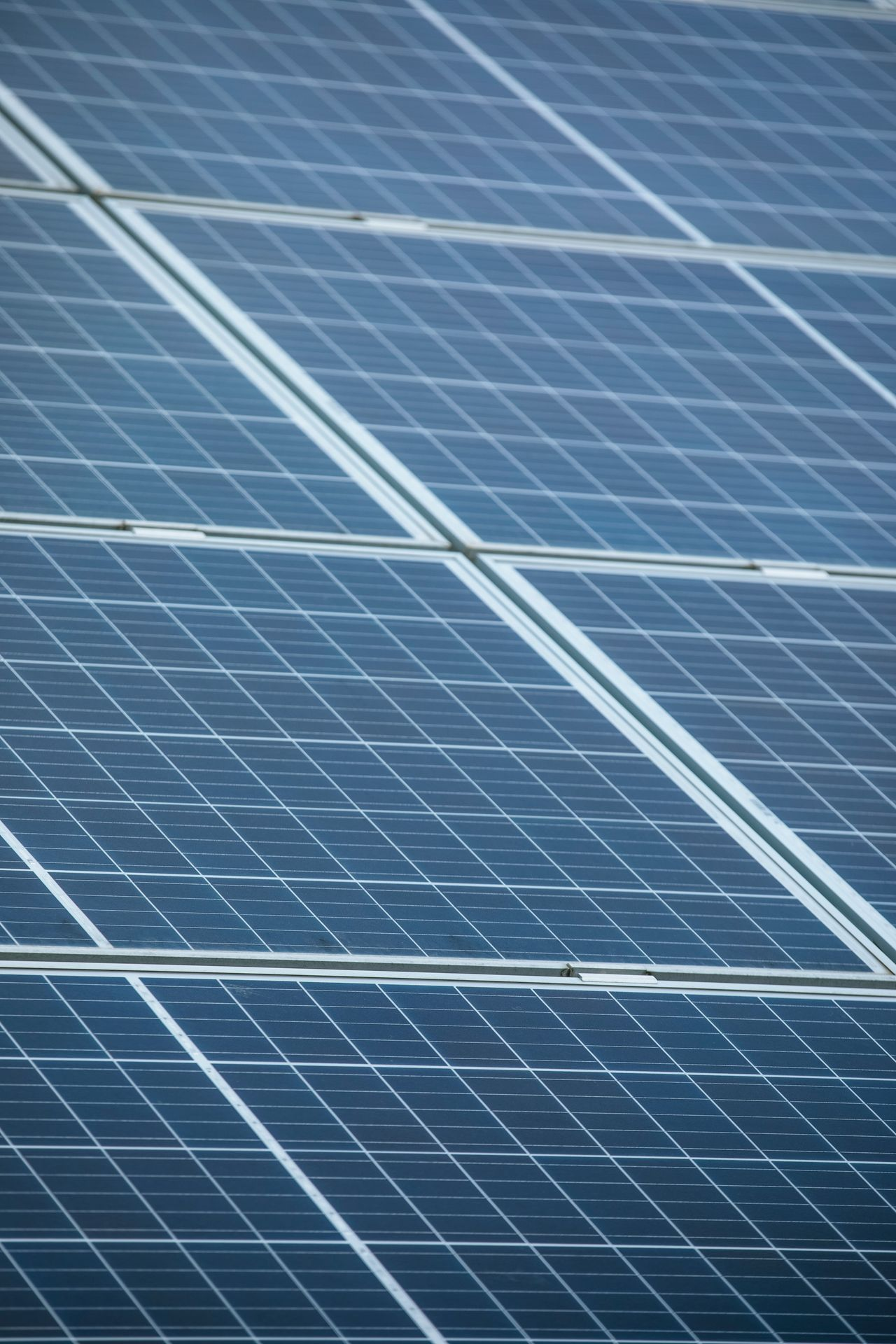 Close-up of clean blue photovoltaic solar panels angled in a neatly mounted array - Cairns City Electrics, Cairns